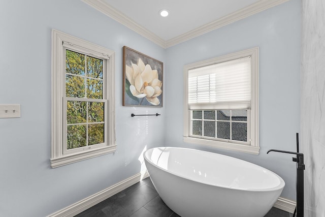 full bath featuring a soaking tub, plenty of natural light, and baseboards