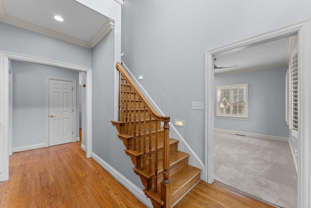 stairs with crown molding, recessed lighting, baseboards, and wood finished floors