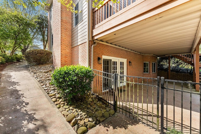 view of side of property featuring fence and brick siding
