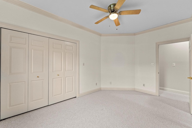 unfurnished bedroom with a closet, baseboards, ornamental molding, and carpet floors
