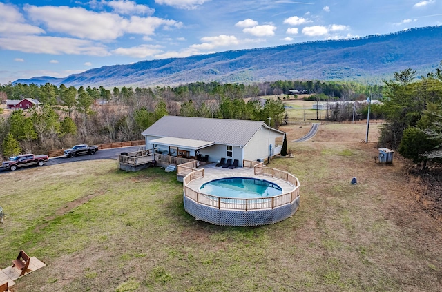 view of pool featuring a lawn and a deck with mountain view