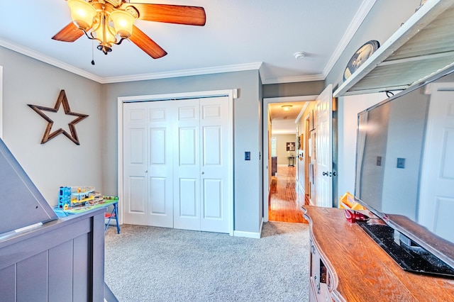 bedroom featuring ceiling fan, crown molding, carpet floors, and a closet