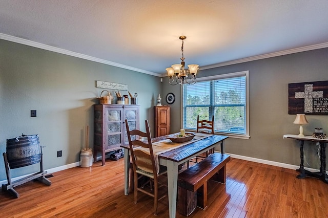 dining space featuring ornamental molding, hardwood / wood-style floors, and a chandelier