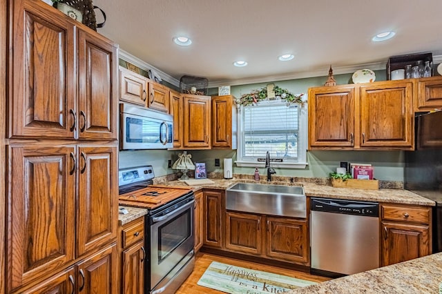 kitchen featuring light hardwood / wood-style flooring, appliances with stainless steel finishes, sink, light stone countertops, and ornamental molding