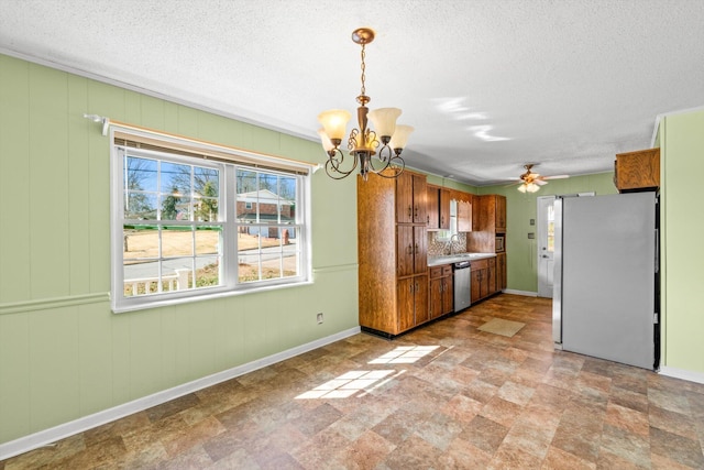 kitchen with sink, hanging light fixtures, a textured ceiling, appliances with stainless steel finishes, and ceiling fan with notable chandelier