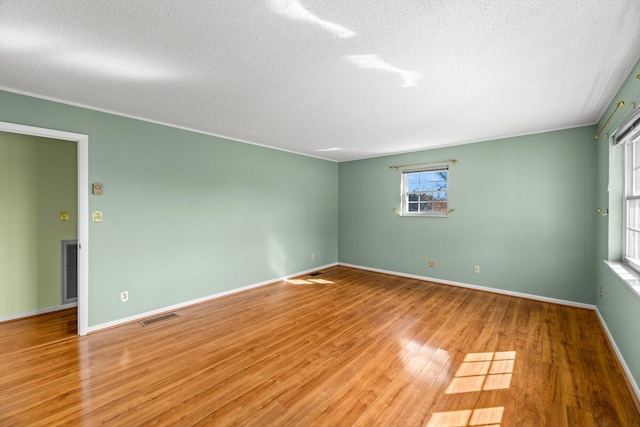 spare room with light hardwood / wood-style flooring and a textured ceiling