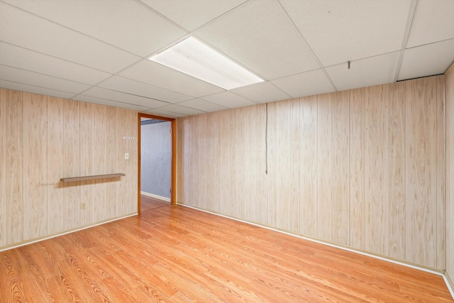 unfurnished room with a paneled ceiling and hardwood / wood-style floors