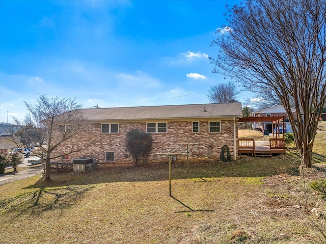 rear view of house featuring a lawn and a deck