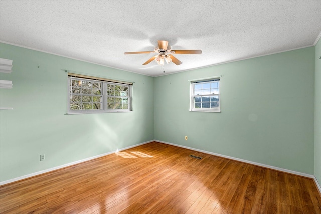 empty room with crown molding, wood-type flooring, a textured ceiling, and ceiling fan