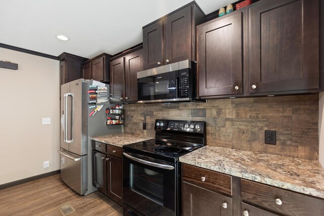 308 S Crisp Ln, Decatur, TN 37322 - kitchen with appliances with stainless steel finishes, decorative backsplash, dark brown cabinetry, light wood-type flooring, and baseboards