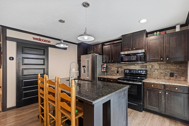 308 S Crisp Ln, Decatur, TN 37322 - kitchen with stainless steel appliances, a sink, backsplash, light wood-type flooring, and a textured ceiling