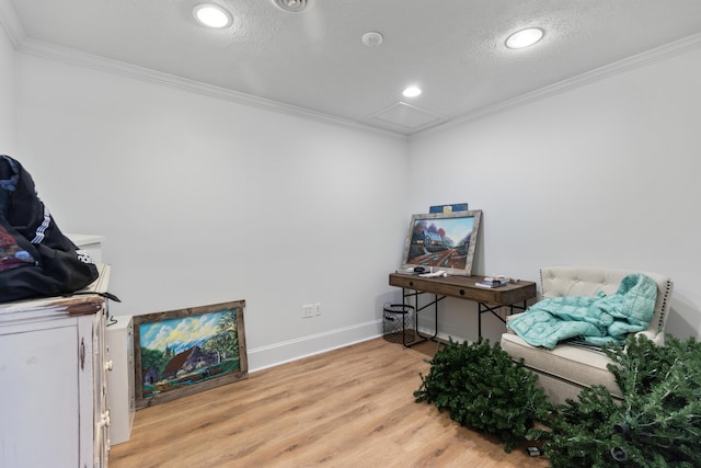 misc room with baseboards, ornamental molding, attic access, and light wood finished floors
