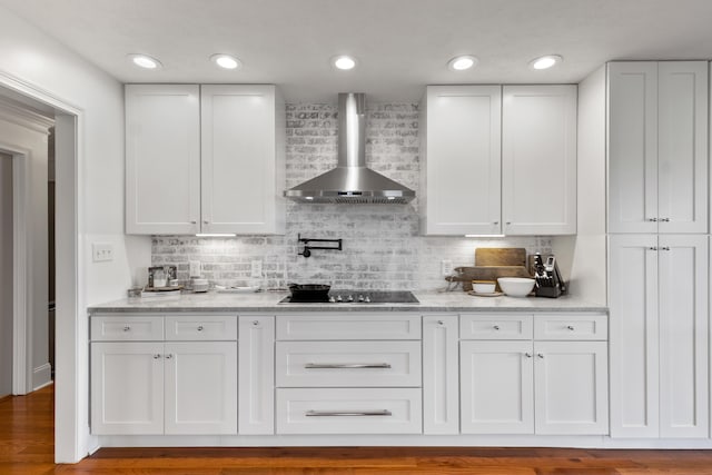 kitchen with white cabinetry, decorative backsplash, black electric cooktop, and wall chimney exhaust hood