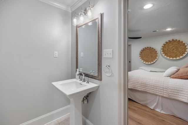 bathroom featuring baseboards, ornamental molding, wood finished floors, and recessed lighting
