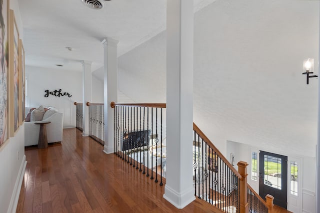 hallway featuring baseboards, visible vents, an upstairs landing, and hardwood / wood-style floors