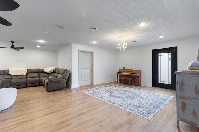 living area featuring recessed lighting, light wood-type flooring, ceiling fan with notable chandelier, a textured ceiling, and visible vents
