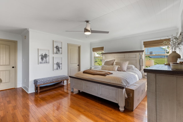 bedroom featuring baseboards, ceiling fan, crown molding, and light wood finished floors