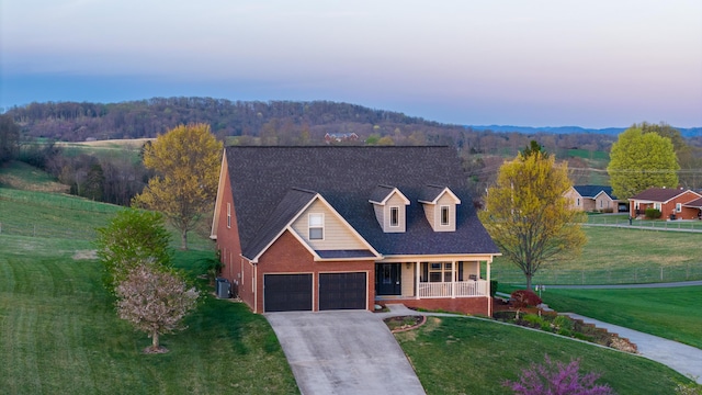 view of front facade with concrete driveway, central AC unit, a front yard, brick siding, and a porch
