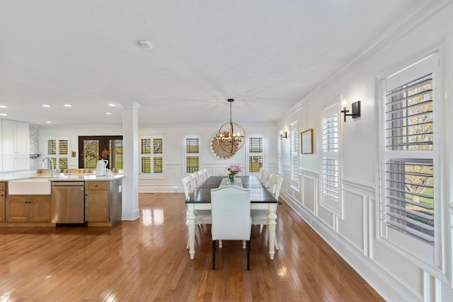 dining space with wood-type flooring, a decorative wall, and plenty of natural light