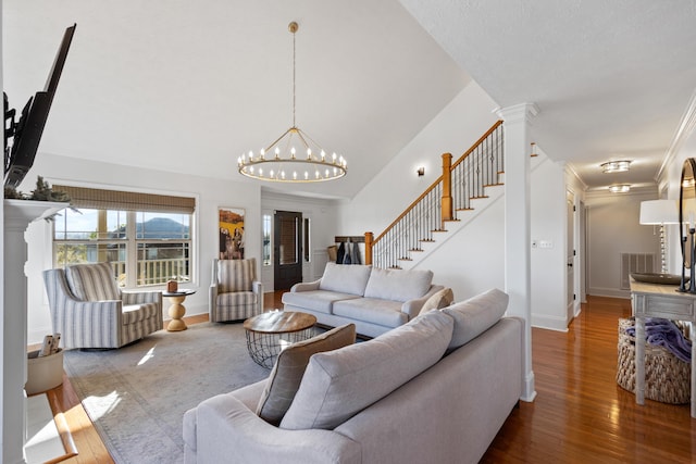 living room featuring stairway, a chandelier, wood-type flooring, baseboards, and visible vents
