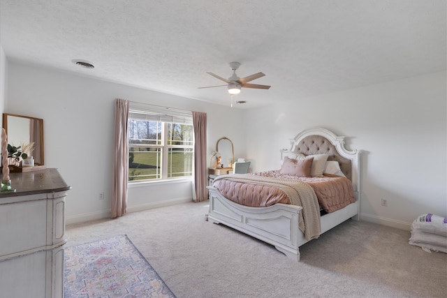 bedroom with light colored carpet, visible vents, baseboards, and a textured ceiling