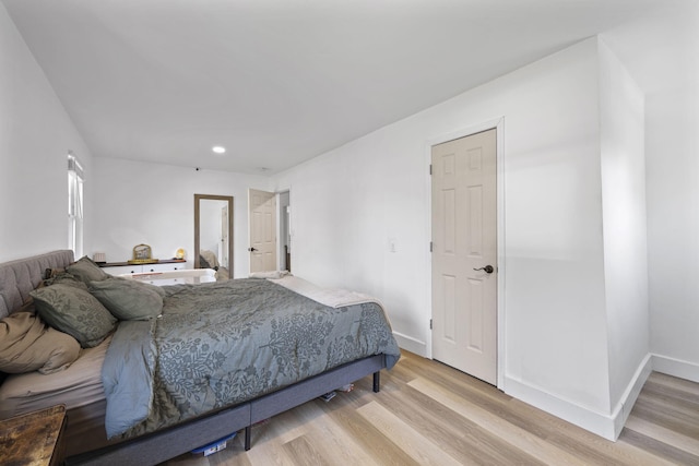 bedroom with light wood finished floors, baseboards, and recessed lighting