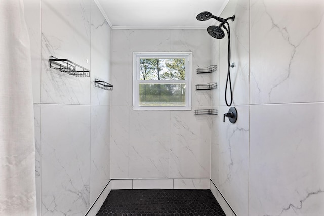 bathroom with ornamental molding and a marble finish shower