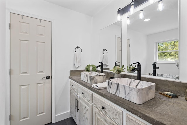full bath with baseboards and vanity