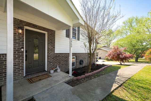 view of exterior entry featuring brick siding