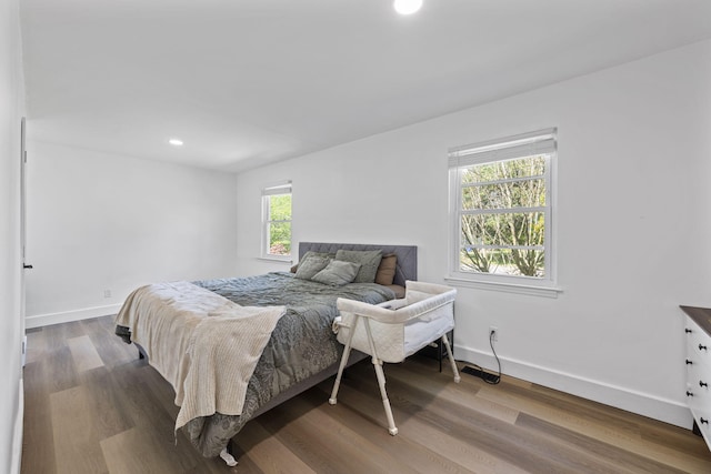 bedroom featuring wood finished floors, baseboards, and recessed lighting