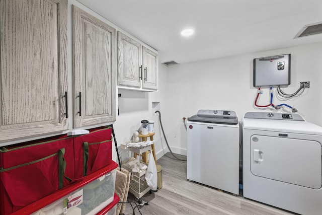laundry room featuring recessed lighting, light wood-style floors, baseboards, washer and dryer, and cabinet space