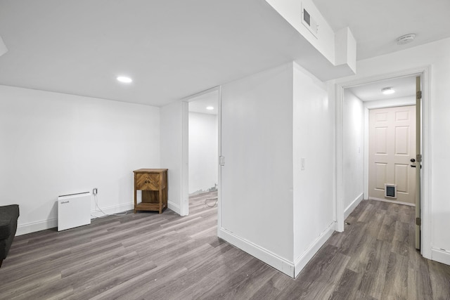 below grade area featuring recessed lighting, wood finished floors, visible vents, and baseboards