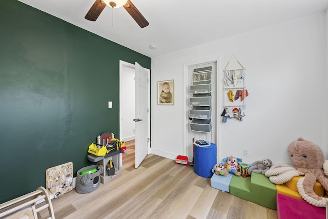 playroom with a ceiling fan and wood finished floors