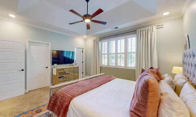 bedroom featuring ornamental molding, visible vents, a raised ceiling, and carpet floors