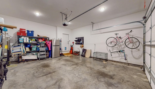 garage featuring a garage door opener and freestanding refrigerator
