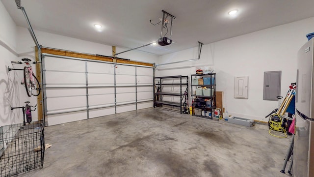 garage with a garage door opener, electric panel, and recessed lighting