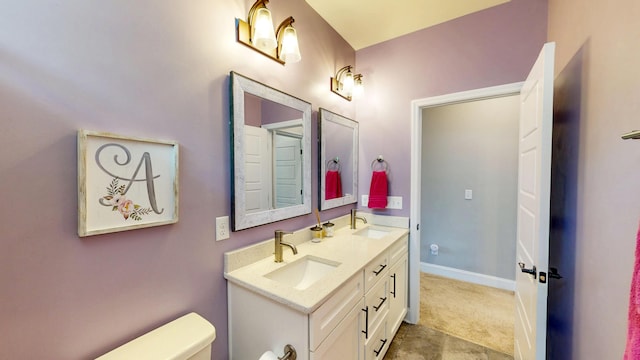 bathroom featuring a sink, toilet, and double vanity