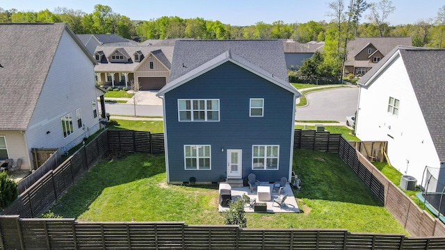 rear view of house with central air condition unit, a fenced backyard, a lawn, a patio area, and a residential view