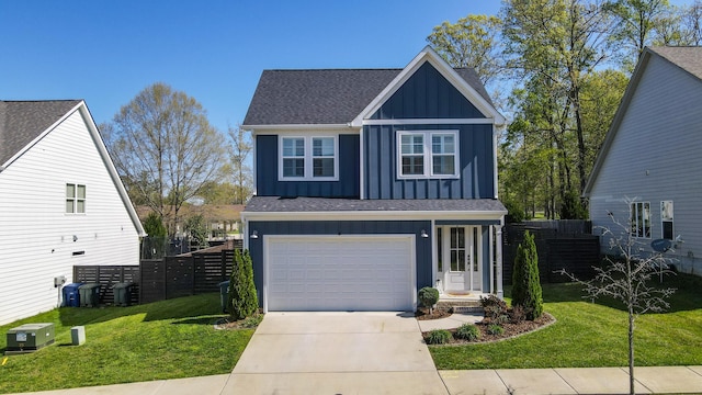 traditional home featuring driveway, board and batten siding, a front yard, a garage, and fence