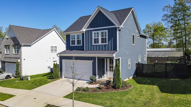 traditional-style house with board and batten siding, a front yard, a garage, and concrete driveway