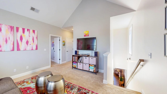 living area with high vaulted ceiling, baseboards, visible vents, and carpet floors