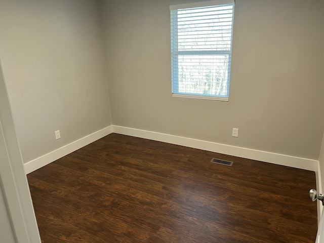 unfurnished room with dark wood-type flooring