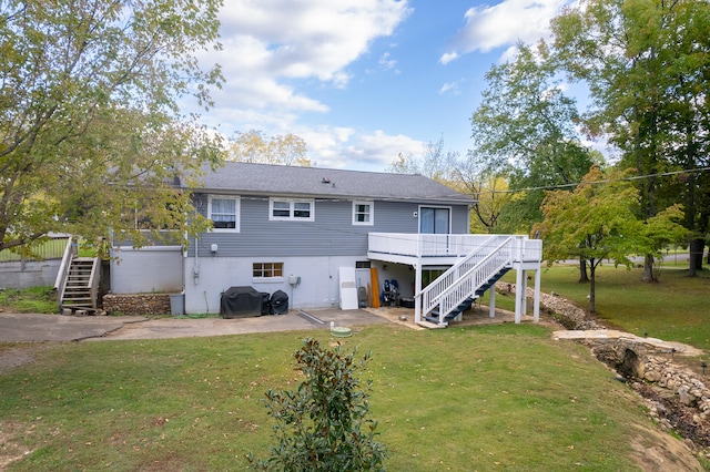 back of house featuring a lawn and a wooden deck