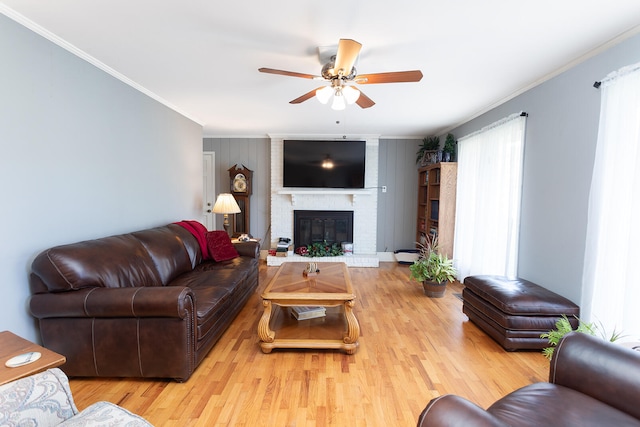 living room featuring a fireplace, light hardwood / wood-style flooring, and crown molding