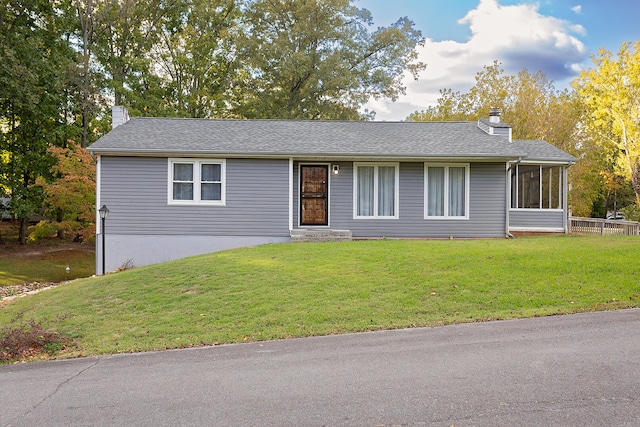 ranch-style home with a sunroom and a front lawn