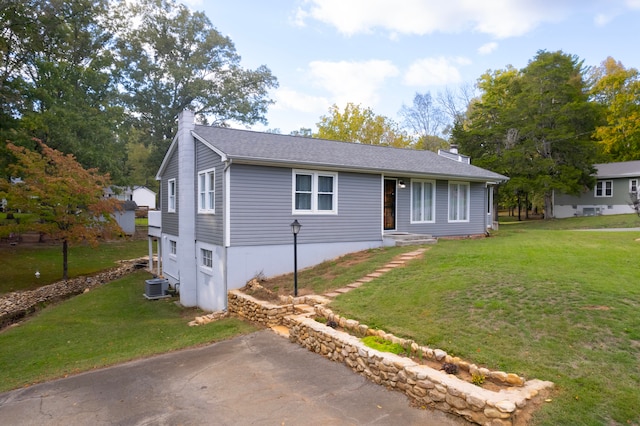 view of front of property featuring cooling unit and a front yard