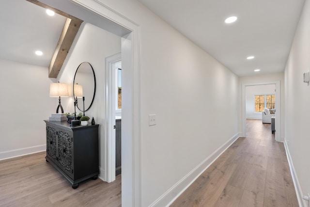 corridor with beam ceiling, recessed lighting, light wood-style flooring, and baseboards