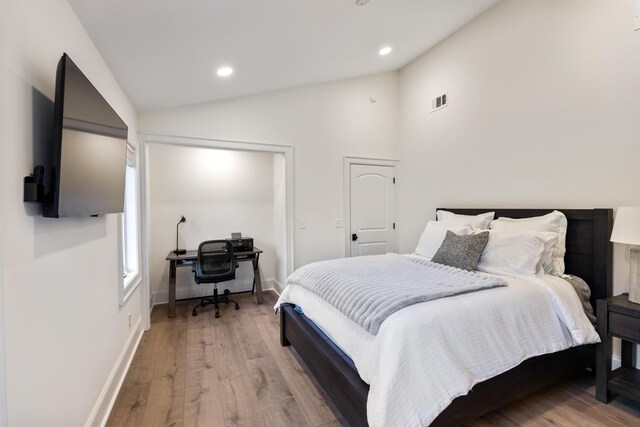 bedroom with vaulted ceiling, light wood-style flooring, and recessed lighting