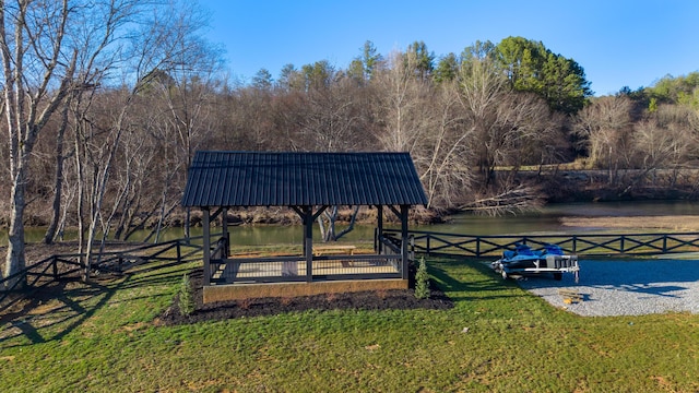 surrounding community featuring a yard, fence, and a water view