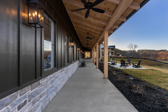 view of patio with a fire pit and a ceiling fan